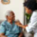nurse helping black senior at home with neutral background.jpg