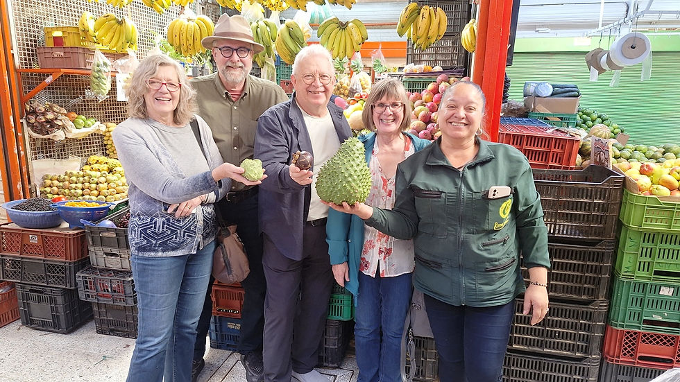 Canadian couples tasting fresh guanabana on a VIP private food tour at Paloquemao market in Bogota.