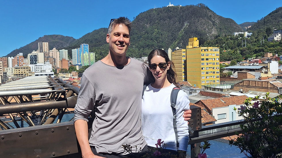 Couple enjoying a city view of Bogota with Monserrate Hill in the background on a clear sunny day.