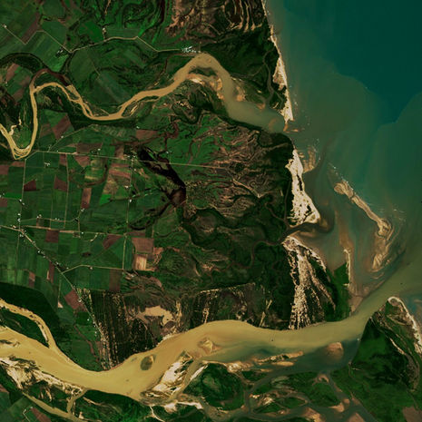 A satellite image of a flood plume, with muddy river water entering the ocean