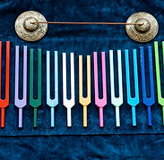 set of colorful metal tuning forks and tibetian bells, acutonic tools of sound healer.jpg