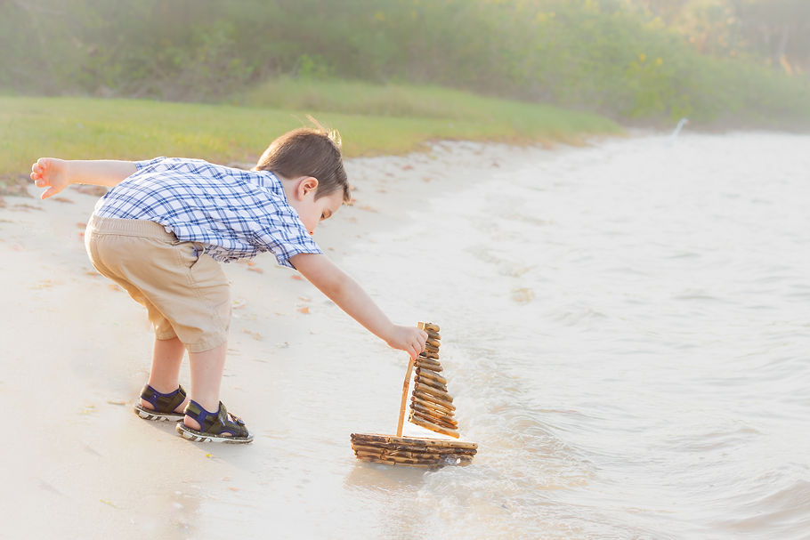 little boy and sailboat in river
