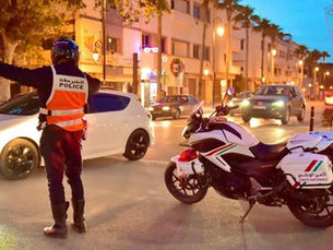 Agent du GPCR régulant la circulation sur un grand carrefour urbain à Casablanca, au milieu d’un trafic dense en pleine journée.