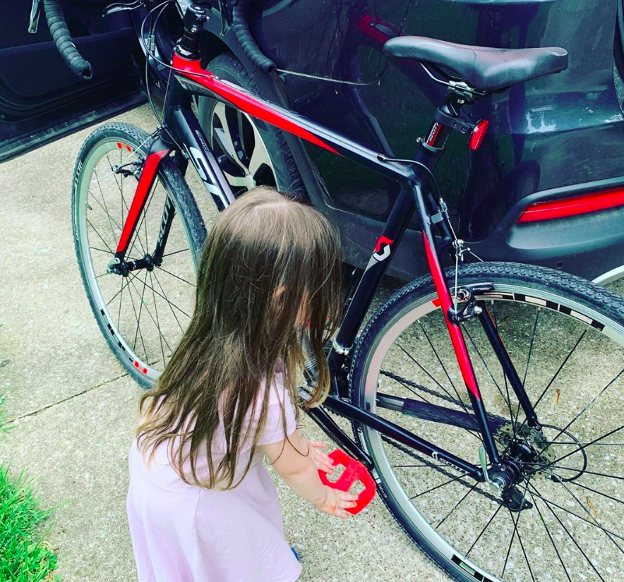 toddler playing with pedals of a road bike