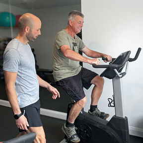 Osteopath Xavier Grech training a patient on an exercise bike