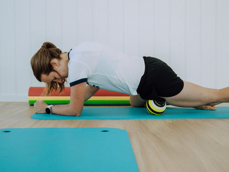 Osteopath Laura Malady rolling her hip flexor muscles with a massage ball