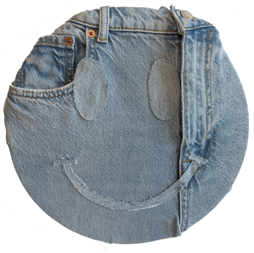 Medium wash denim circle made from jean waistband and pocket, with two oval eyes and a curved cut denim smile, forming a face.