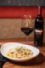 High angle view of a cheerful group of friends sharing a large platter of pasta