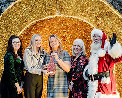 Santa Claus with four women accepting an award