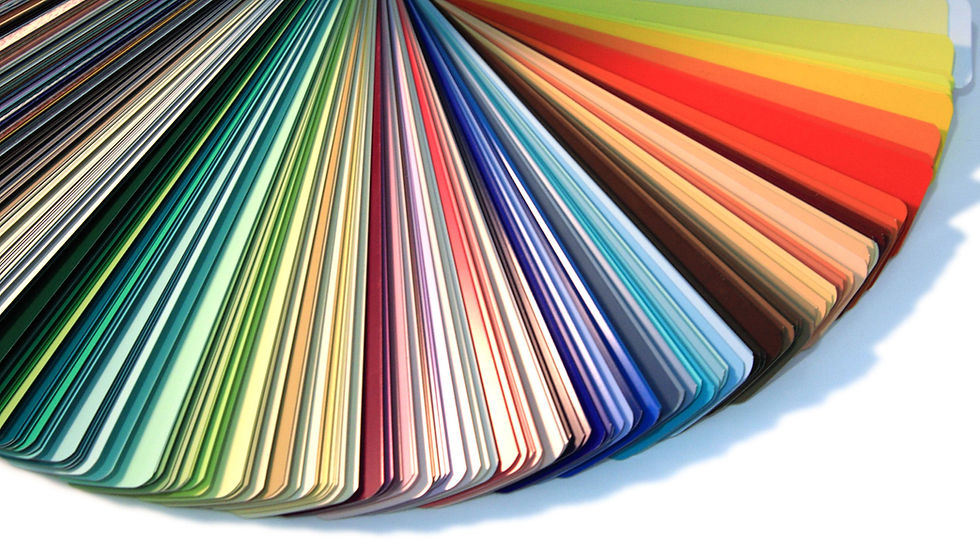 Fan of color swatches spread in a rainbow gradient, from dark greens and blues to reds and yellows, on a white background
