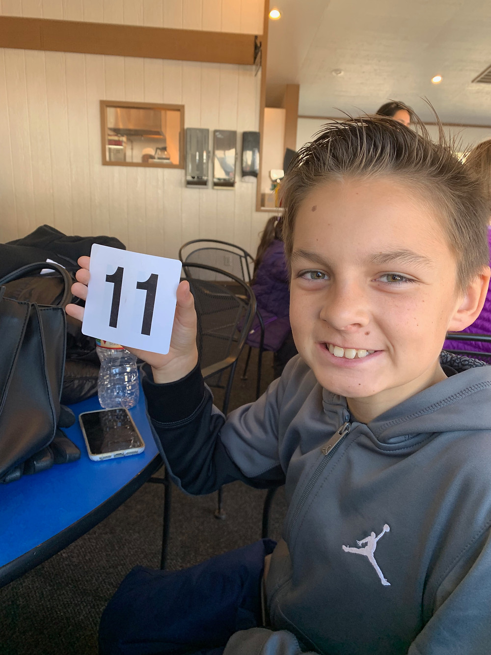 Boy holding restaurant sign 11