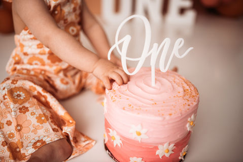 Closeup on hand in one year old cake.