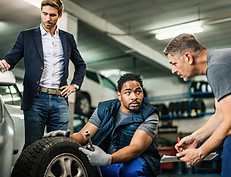two-auto-mechanics-cooperating-while-repairing-tire-customer-s-car-auto-repair-shop.jpg