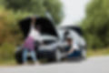 woman-checking-engine-man-swapping-tire.jpg