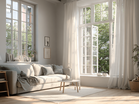 Habitació lluminosa amb finestres obertes i cortines blanques movent-se amb la brisa per ventilar i eliminar l’olor de fum.