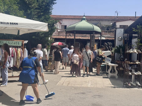 Operària de Net i Pulit escombrant les zones de pas del Mercantic de Sant Cugat entre parades i visitants, un cap de setmana.