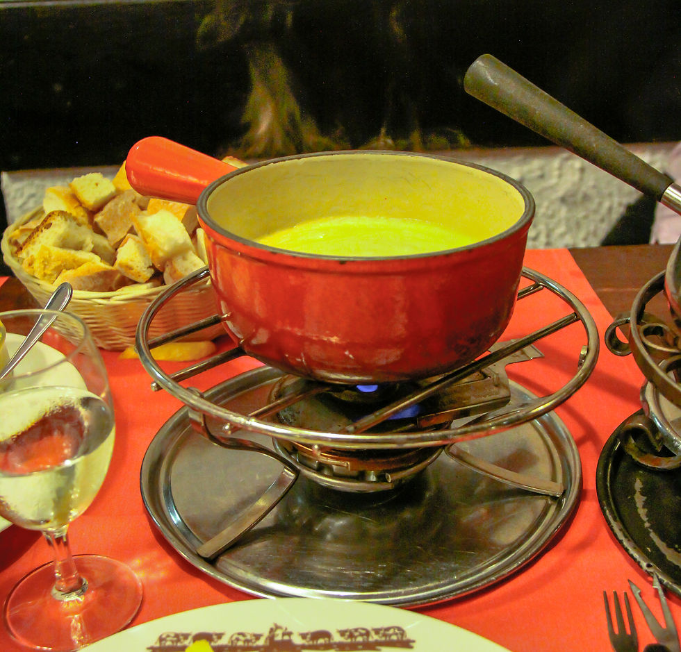 A classic Swiss cheese fondue is served hot, in a heavy fondue pot, with cubes of fresh bread for dipping and white wine