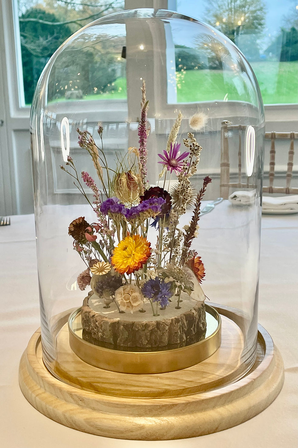 Thumbnail: Handmade Flower Dome ft. homegrown blooms, encased in a glass dome with brass base on event table