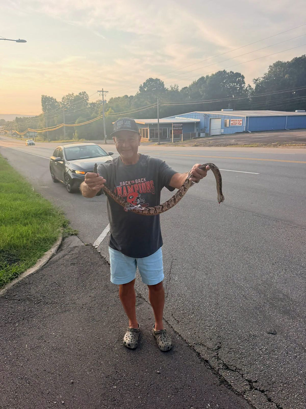 Jeff Morton is pictured with a rattlesnake that had been struck near Cherokee Glass at the intersection of Pratt Street and West Main Street in Cherokee County. Photo courtesy of WEIS Radio/Facebook.