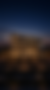مبنى سكني حديث مضاء ليلاً يطل على شارع رئيسي