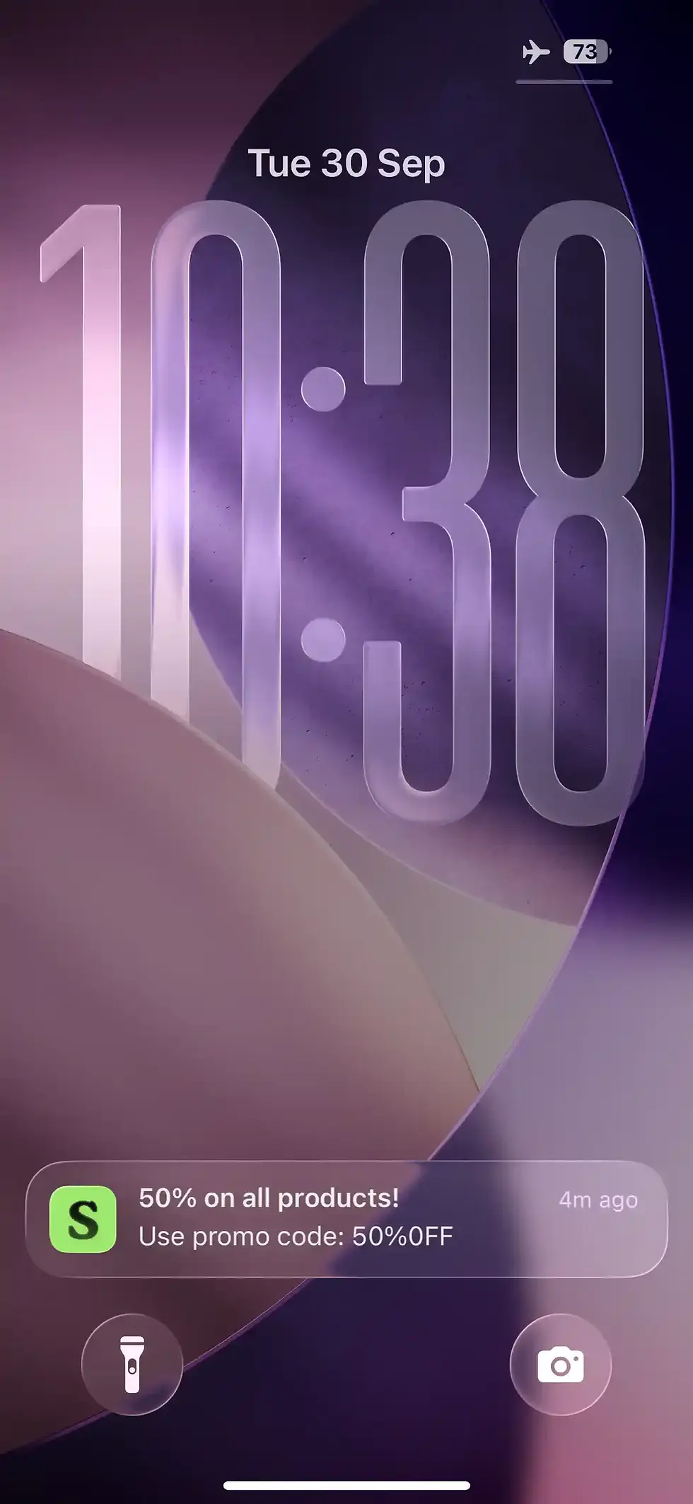 iPhone lock screen with date, time, and promotion of 50% off products.