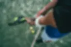Padel player holding a racket and adjusting a wristband