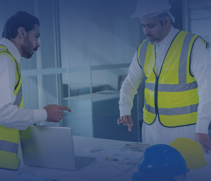 مهندسان يناقشان خططًا على جهاز كمبيوتر محمول