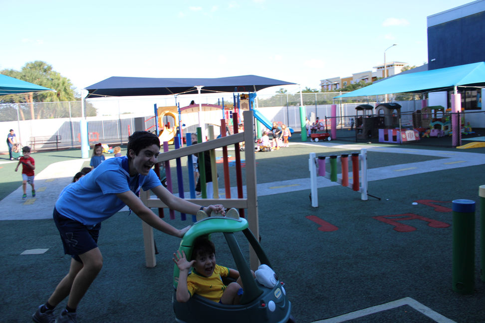 A madrich driving his chanich around the playground!