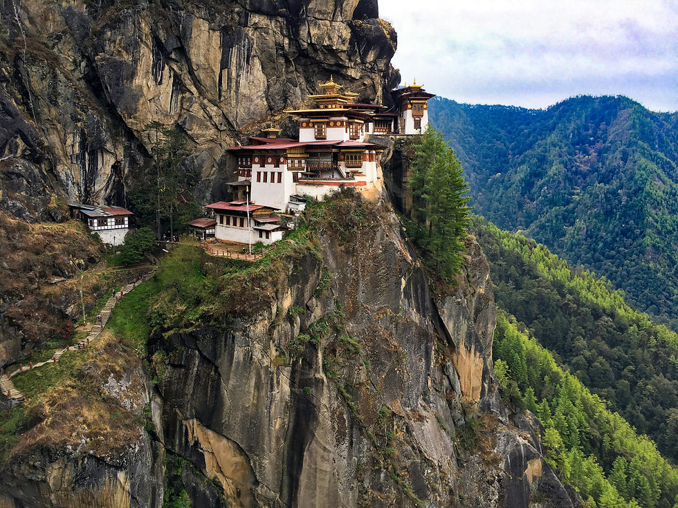 The Paro Taktsang, also known as the Tiger's Nest Monastery, precariously perched on the cliffside of the Paro Valley, surrounded by lush greenery and rugged mountains in Bhutan.
