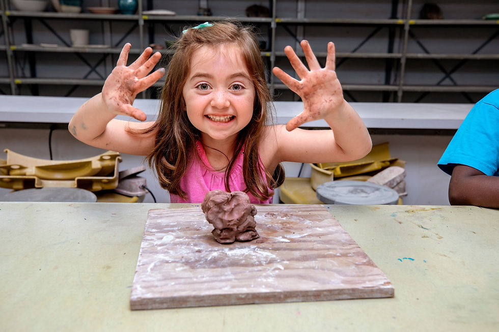 Students sit at table creating art together