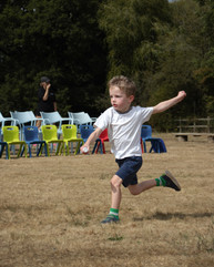 Focused boy participating in a relay race, showcasing determination and active learning during outdoor nursery play