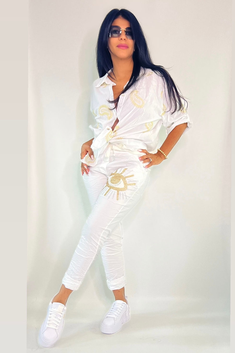 Miniatura: Woman in white shirt and pants with sun designs