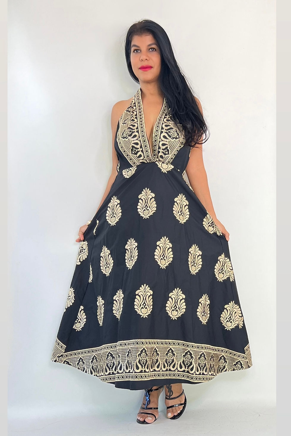 Miniatura: Woman in a black dress with intricate gold patterns