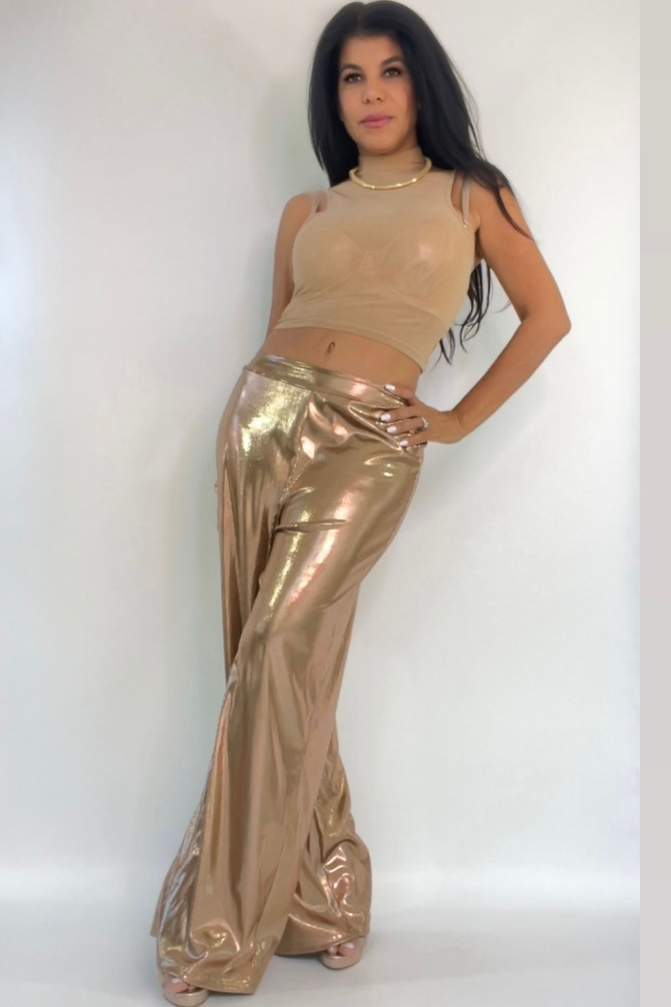 Miniatura: Model in beige sleeveless crop top and gold pants