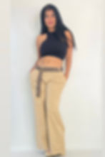 Woman in black halter top, beige pants, and patterned belt