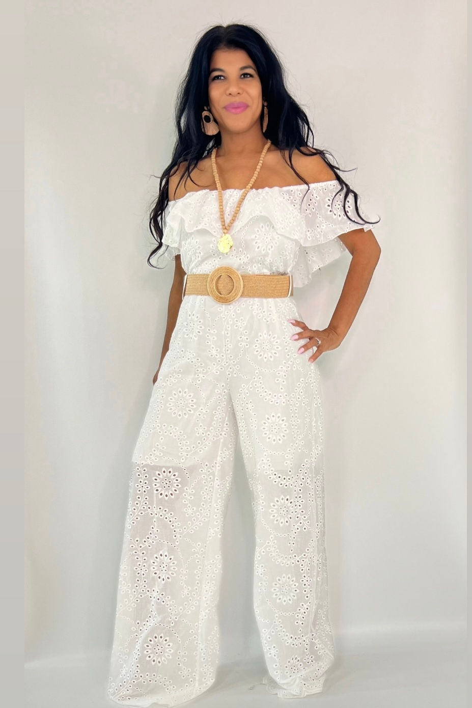 Thumbnail: Woman in white off-shoulder eyelet jumpsuit with woven belt
