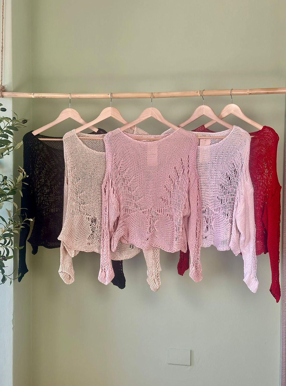Miniatura: Five knit tops in black, beige, pink, light pink, and red on hangers