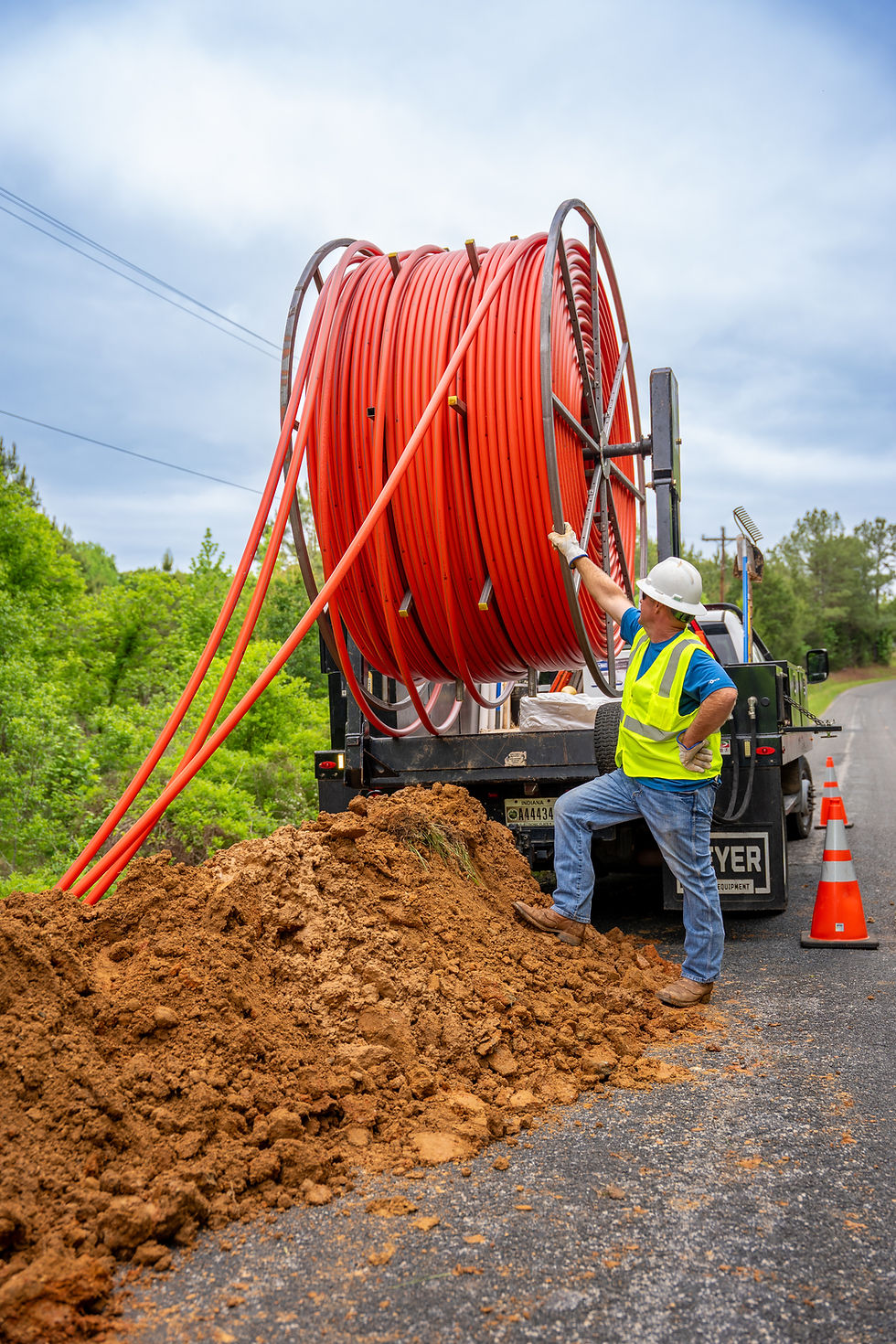 Worker with fiber optic cable, power and fiber construction.