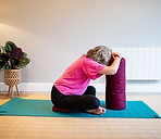 Vicky sitting cross-legged with head and hands resting on bolster.