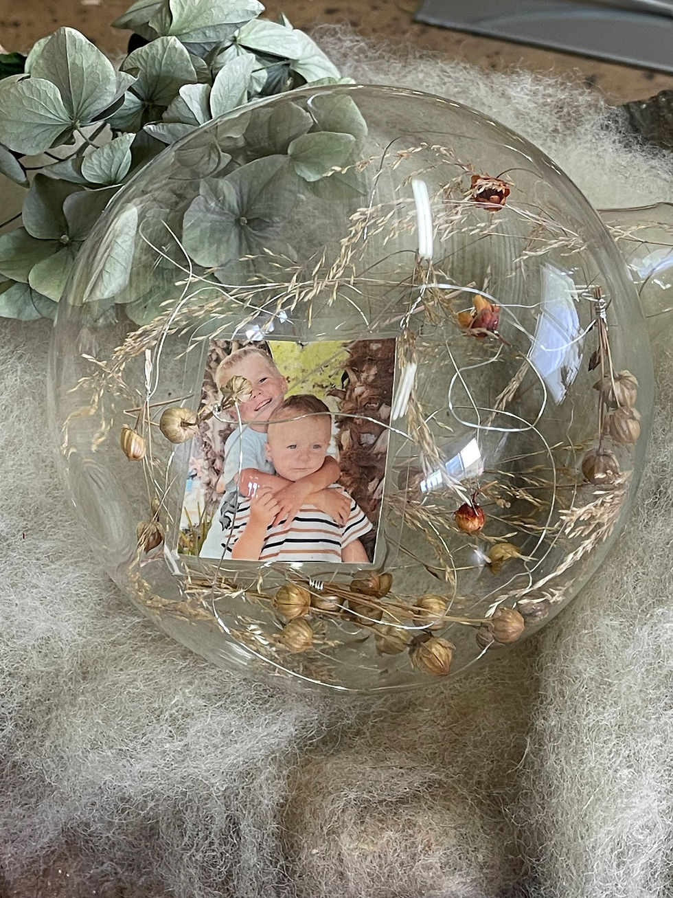Glaskugel mit Trockenblumen und Foto