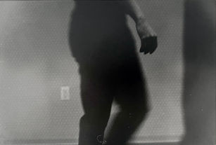 Photo of a figure from waist to ankles, with only the hand in focus
