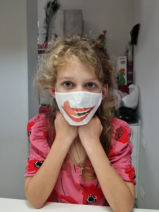 posing playfully while wearing a custom reusable face mask.