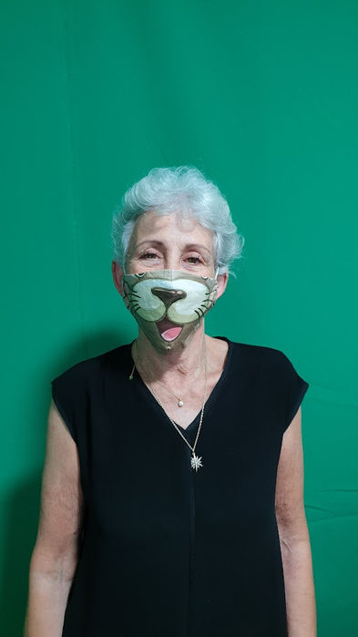 Older woman smiling while wearing a colorful custom-designed face mask.