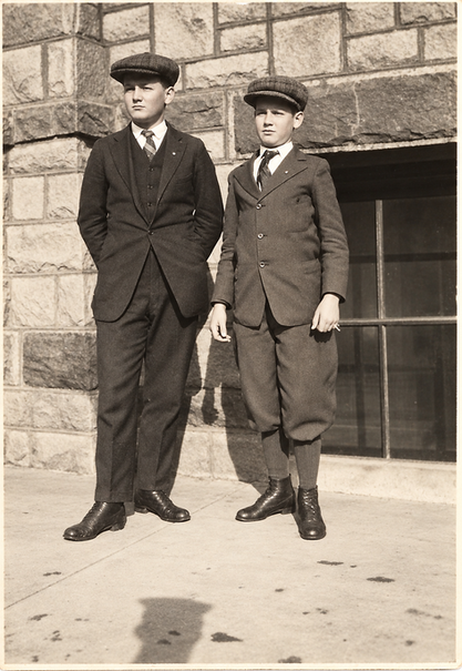 Young SDSD students Guy and Abel Sylliaasen posing together in suits and flat caps, circa 1914–1915.