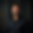 a_confident_smiling_middle_eastern_businessman_wearing_a_dark_shirt_standing_in_front_of_a