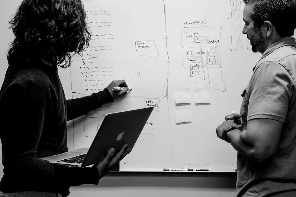 A man and a woman collaborating on a whiteboard
