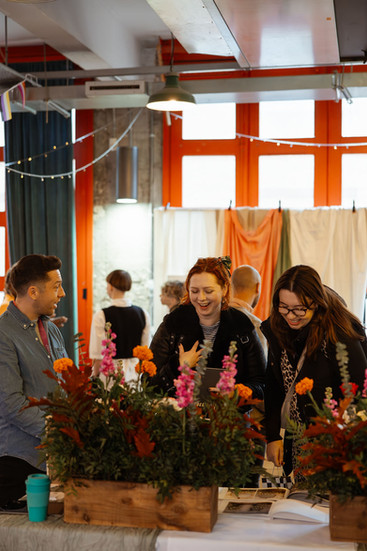 A queer couple look at flowers on display at the first ever Rebel love Wedding Fair in Bristol at The Station