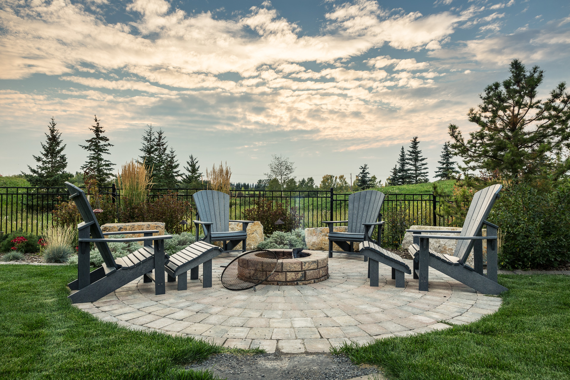 Year-Round Landscaping residential stone patio with fire pit and garden planting