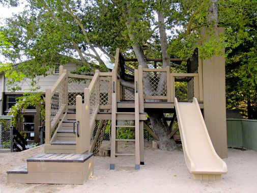 Front view of rope net treehouse of transfer steps, ladder and slide
