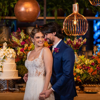 Casal em trajes de casamento; bolo e flores; Bride's Dream em fundo.